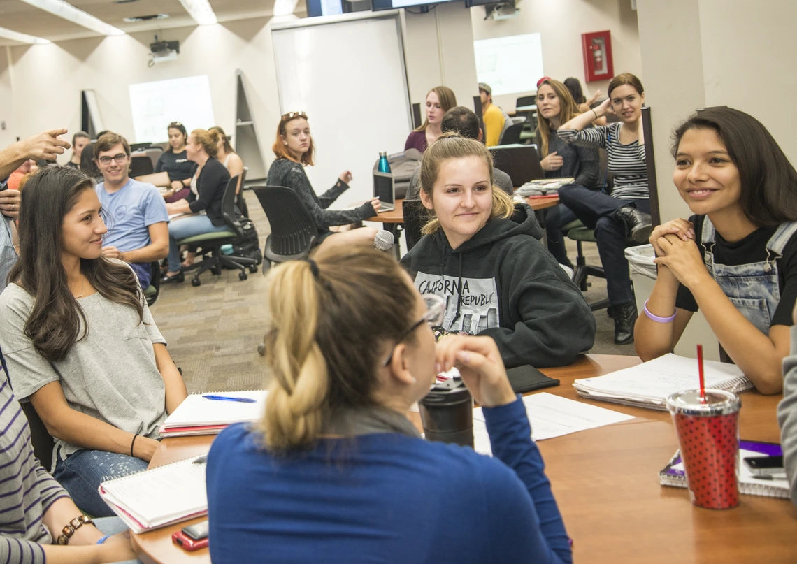 An instructor talking to a group of students in a class.